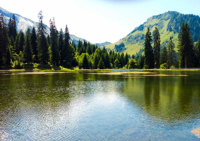 Scenic view of lake by mountain against sky