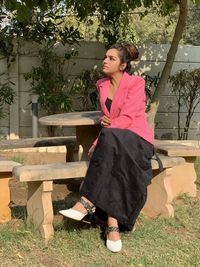 Woman sitting on bench in park