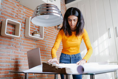 Woman looking at camera while standing on table