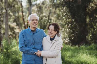 Portrait of senior active couple embracing outside