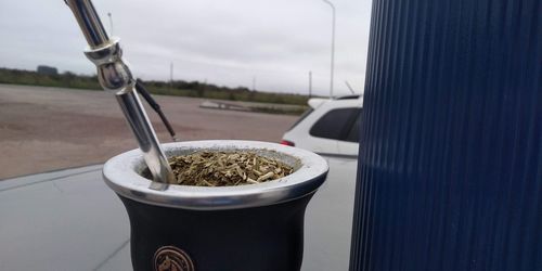 Close-up of beer in container against sky