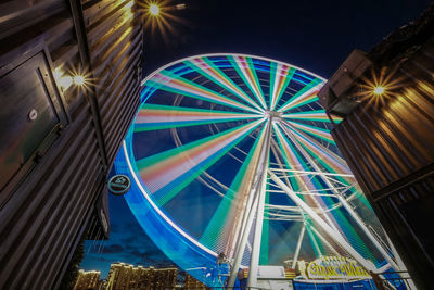 Low angle view of illuminated ferris wheel at night