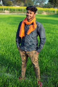 Portrait of smiling young man standing on field