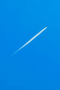 Low angle view of vapor trail against blue sky