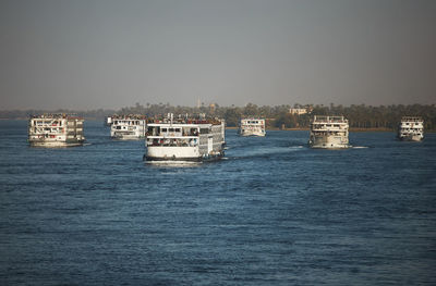 Boats in sea against clear sky