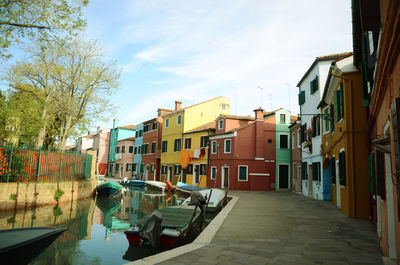 Canal amidst buildings in city against sky