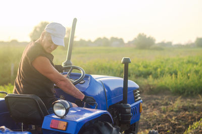 A farmer on a tractor drives across the farm field. agricultural management skills and earthworks