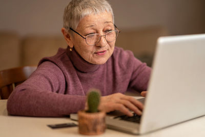 Portrait of man using laptop at home