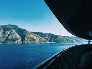 Scenic view of sea and mountains against clear sky