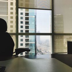 Rear view of man sitting on glass window