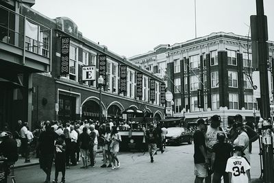 People on street against buildings in city