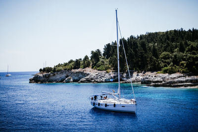 Sailboat sailing on sea against clear sky