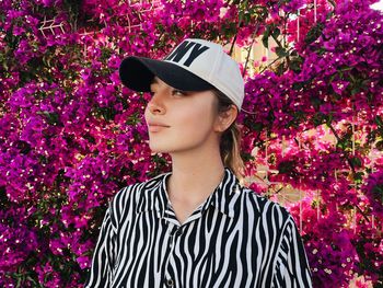 Portrait of young woman standing against plants