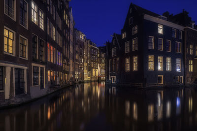 Reflection of buildings in canal at night