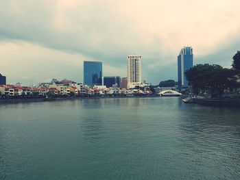 River by cityscape against sky