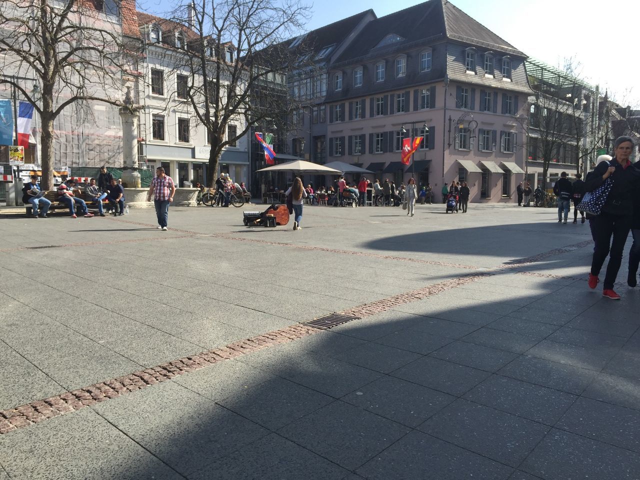 building exterior, architecture, built structure, street, city, men, lifestyles, walking, city life, person, city street, large group of people, leisure activity, road, transportation, cobblestone, incidental people, road marking, building