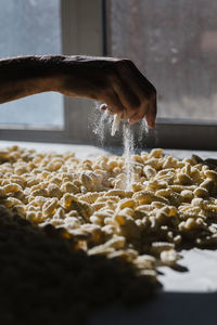 Cropped hand of man preparing food on table