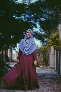 Young woman wearing hijab on footpath