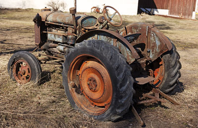 Close-up of abandoned tractor on field