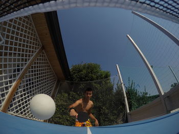 Shirtless man playing table tennis