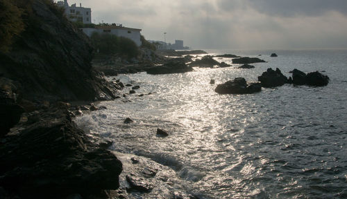 Rock formation on beach against sky