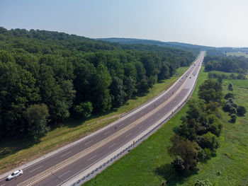 An aerial view of a highway bordered by trees.