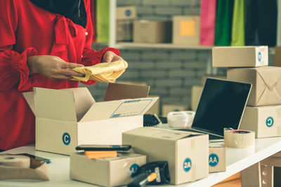 Midsection of woman standing by boxes