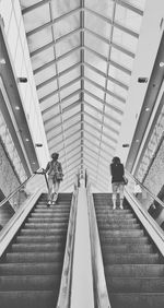 Low angle view of people walking on escalator