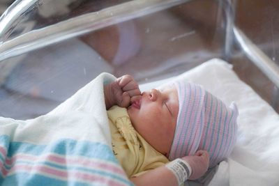 High angle view of baby girl sleeping in glass container at hospital