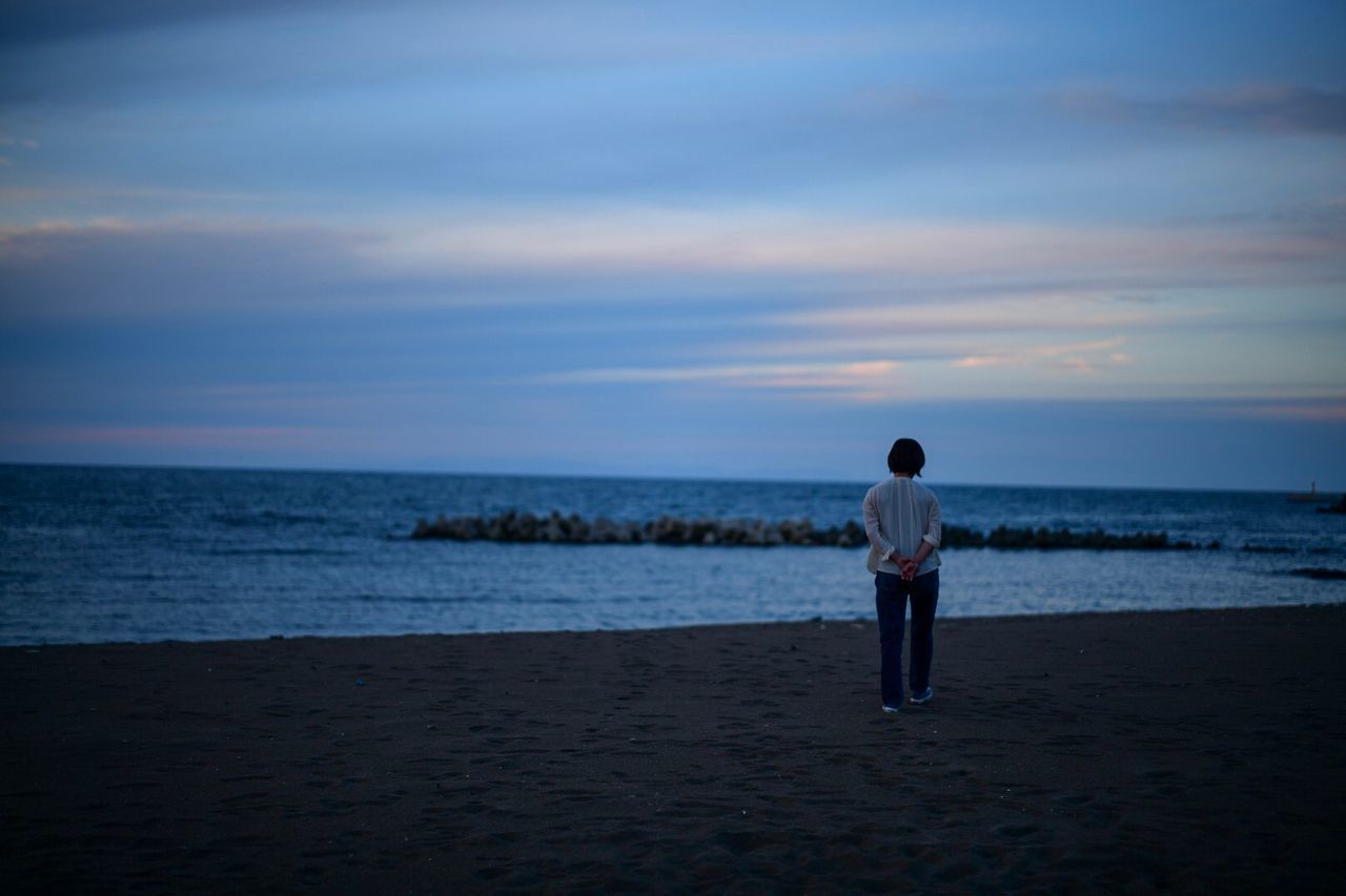 sea, sky, water, horizon over water, beach, beauty in nature, horizon, land, real people, scenics - nature, cloud - sky, sunset, rear view, leisure activity, one person, standing, lifestyles, tranquility, men, outdoors, looking at view