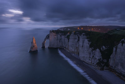 France, normandy, etretat, falaise daval cliffs and aiguille detretat sea stack at cloudy dusk