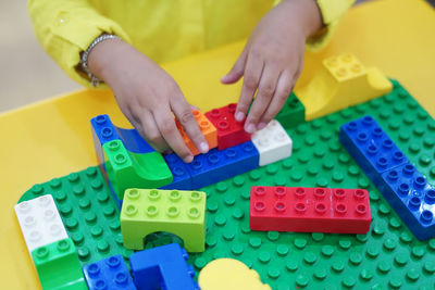 Midsection of girl playing with toy blocks