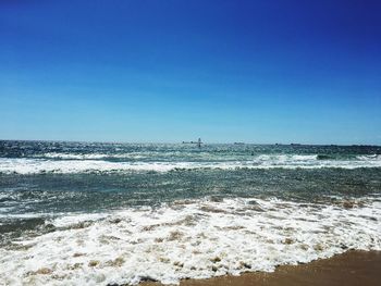 Scenic view of beach against clear blue sky