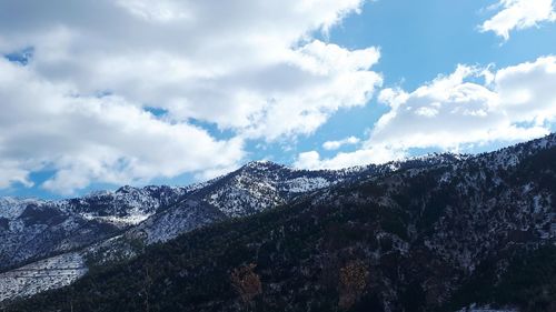 Low angle view of snowcapped mountains against sky