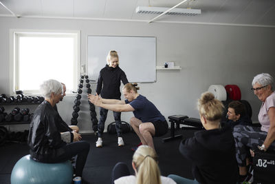 Smiling people exercising together in gym