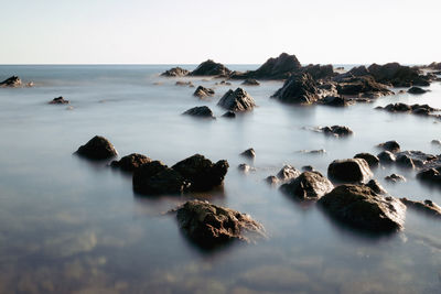 Rocks in sea against sky