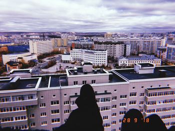 Rear view of man and woman against buildings in city