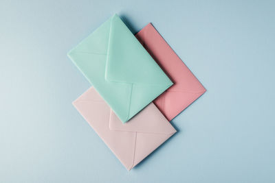 Collection of envelopes in pastel colors on a light blue background.