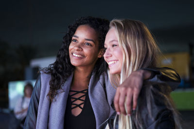 Two happy young women outdoors at night