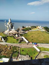 High angle view of statue by sea against sky