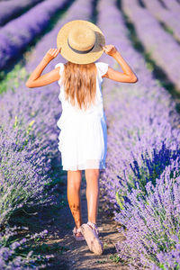 Full length rear view of woman standing on rock