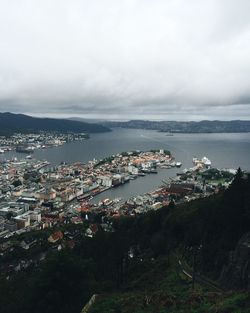 Aerial view of city by sea against sky