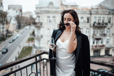 Full length of woman standing against railing in city