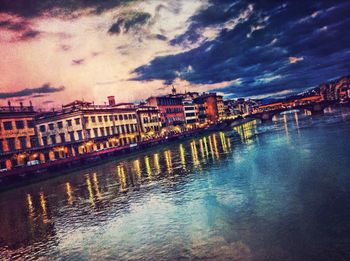 River in city against cloudy sky