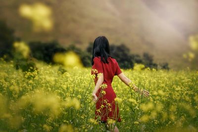 Rear view of woman standing on field