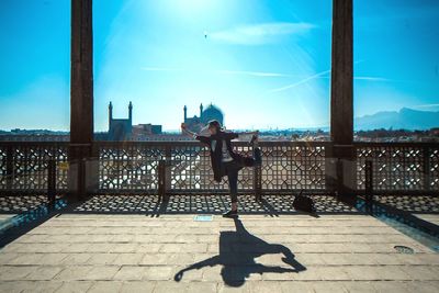 Shadow of woman on railing against sky