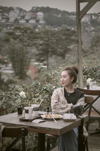 Young woman using laptop while sitting on table