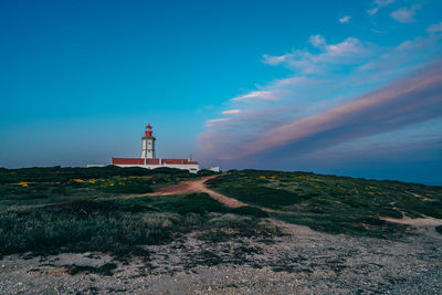 Lighthouse by sea against sky