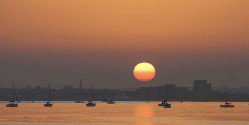 Scenic view of sea against orange sky