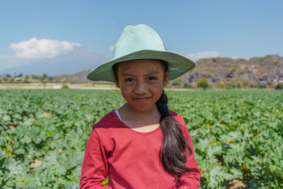 Portrait of woman wearing hat standing on field against sky